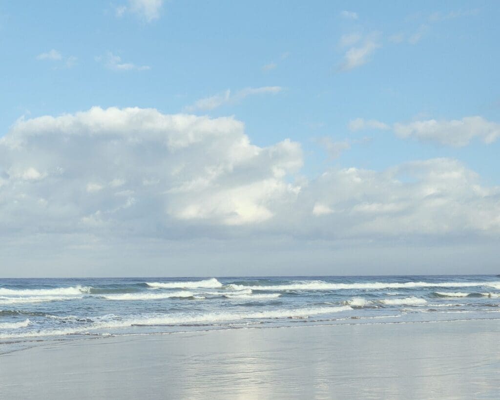 calm ocean waves and soft clouds over a peaceful beach