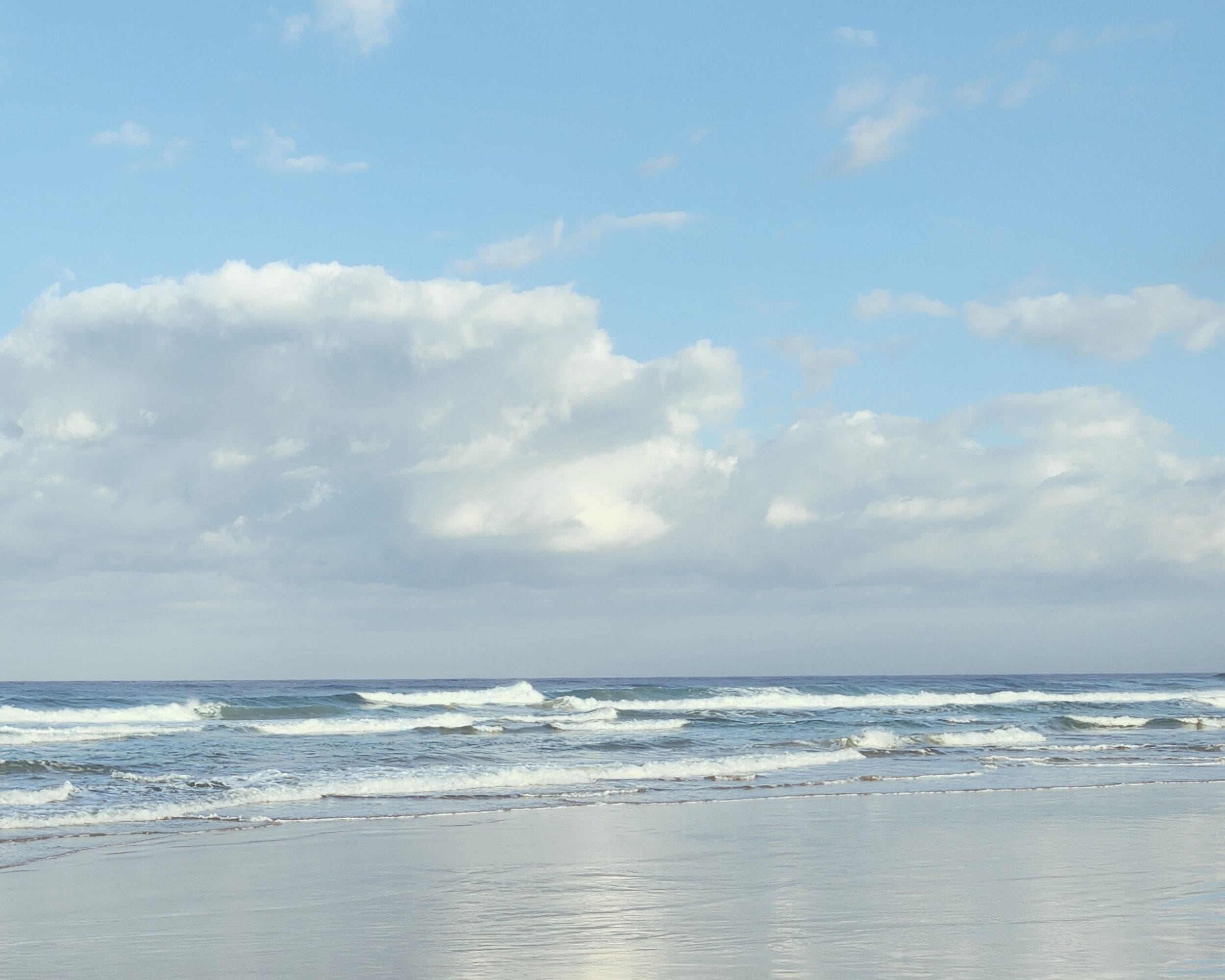 calm ocean waves and soft clouds over a peaceful beach